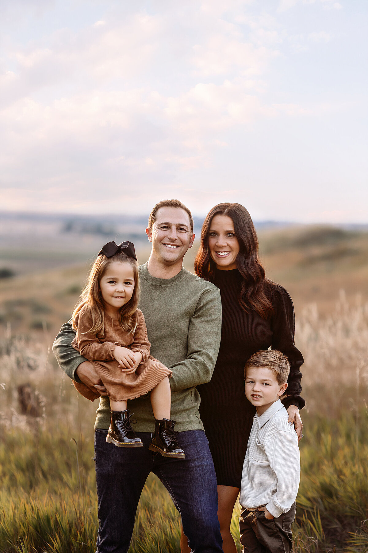 A family walks through vibrant fall leaves in Boulder during their golden-hour fall mini session.