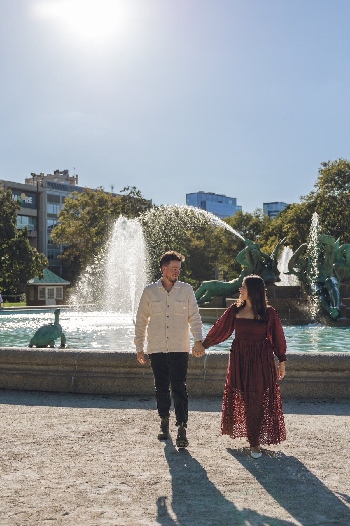 Couple walking together by the fountain in Philadelphia's Old City.