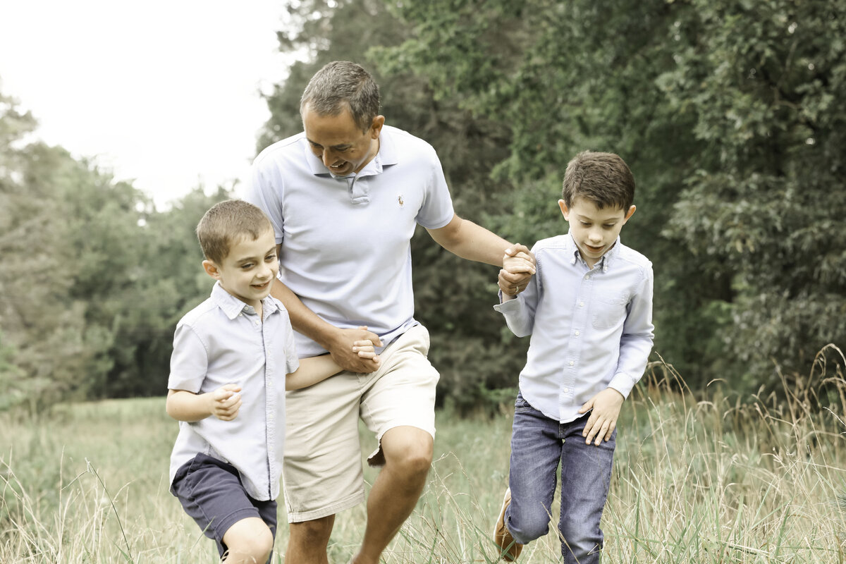 father and sons walking in a field