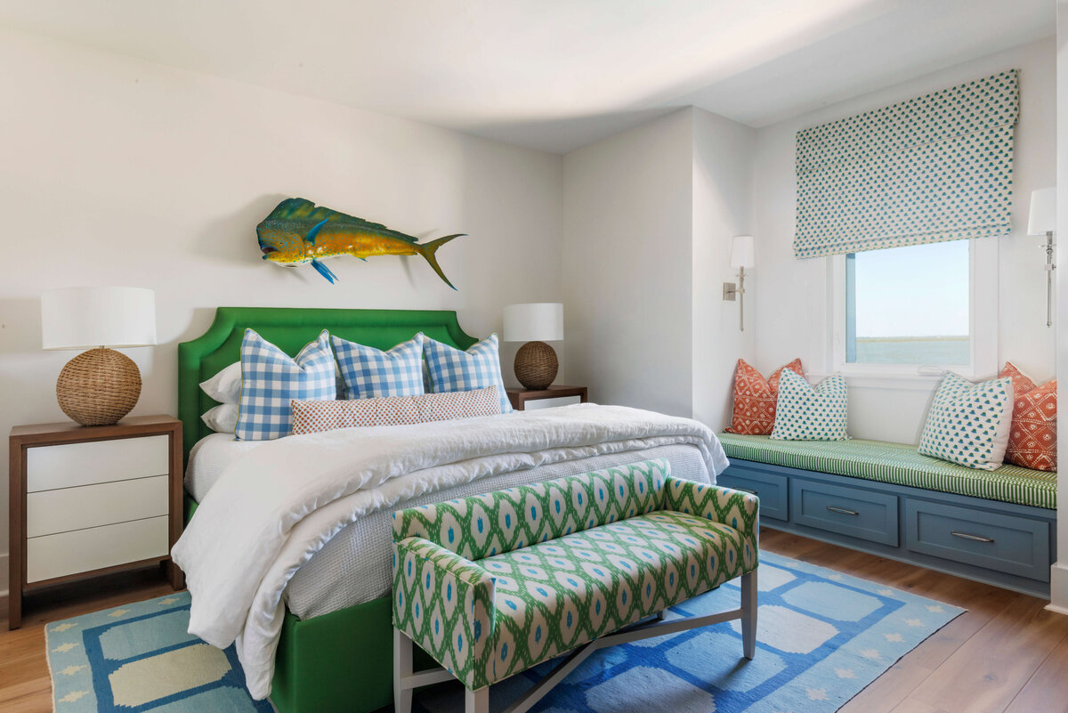 oyster creek studios lighthouse on the lake green bed frame with white bedding and blue plaid pillows with fish decoration in bedroom