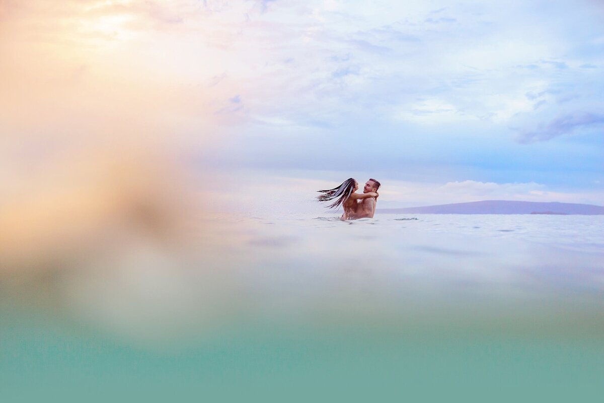 Abstract water portraits with couple embracing in the ocean during a cloudy sunset photographed by Love + Water in Maui