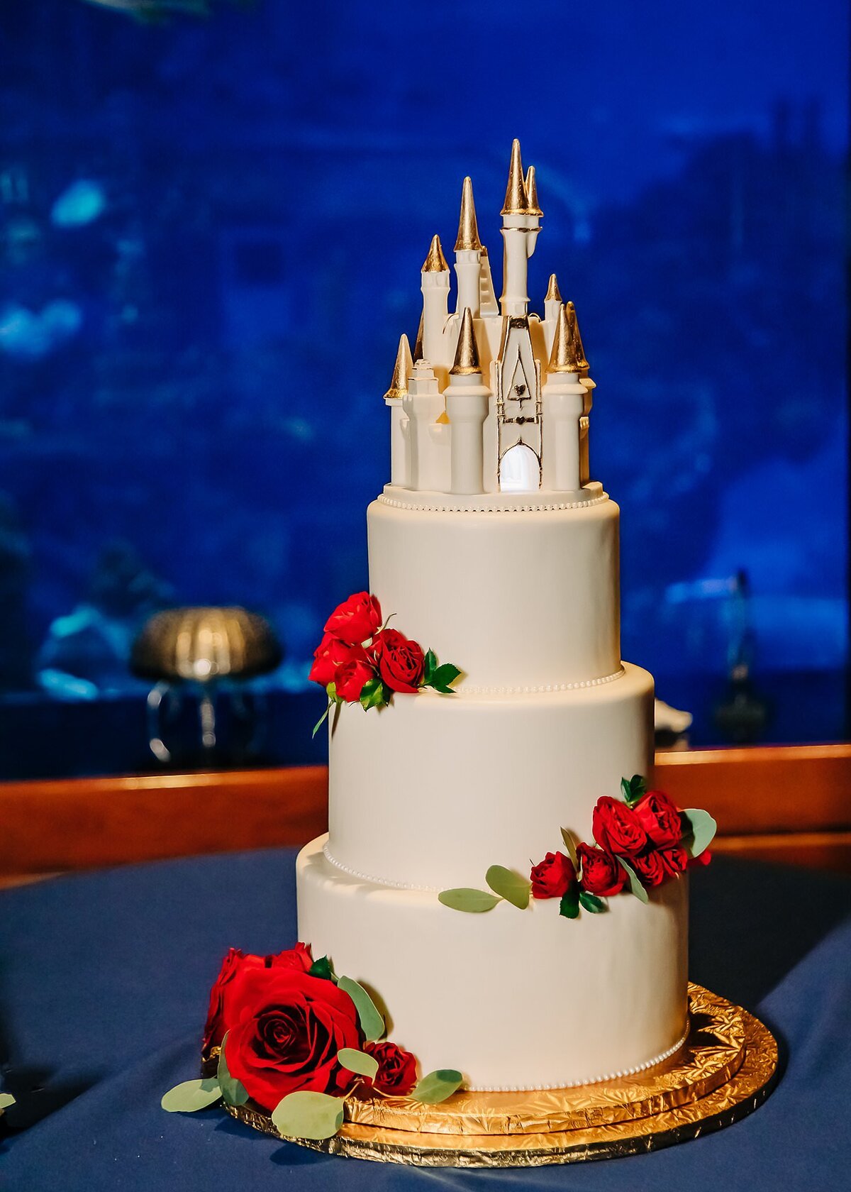 Wedding cake with castle topper at Disney Living Seas reception