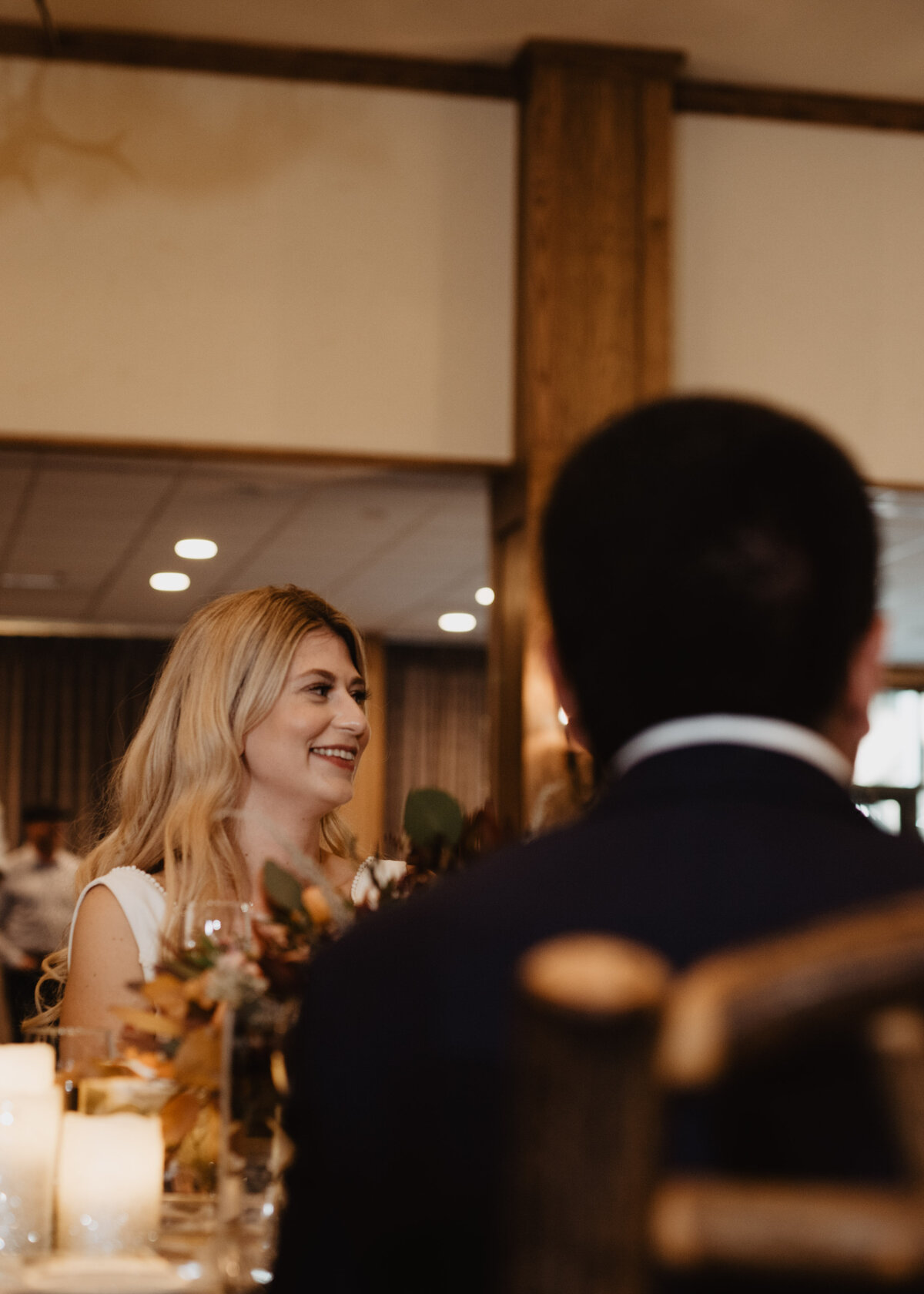 Photographers Jackson Hole capture bride smiling at groom during speech