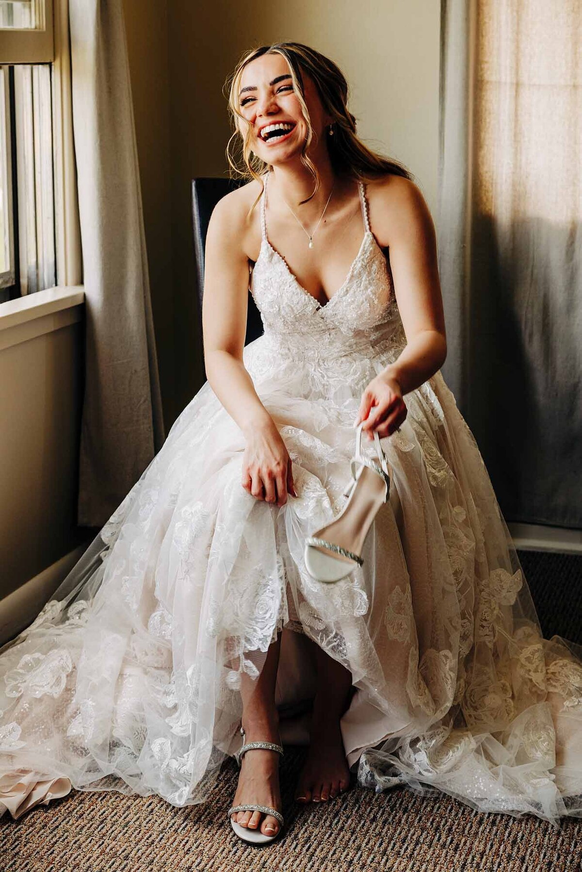 Bride laughing and putting on shoes in Helena, MT