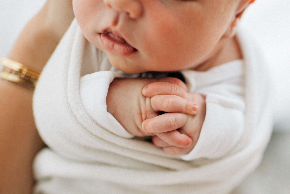 close up view of newborn baby's hands clasped together