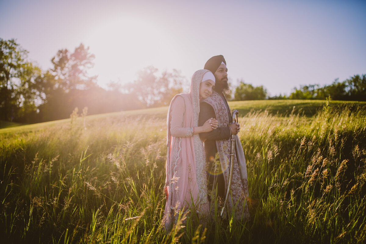 Sikh amritdhari couple standing in an open field in michigan after their anand karaj wedding