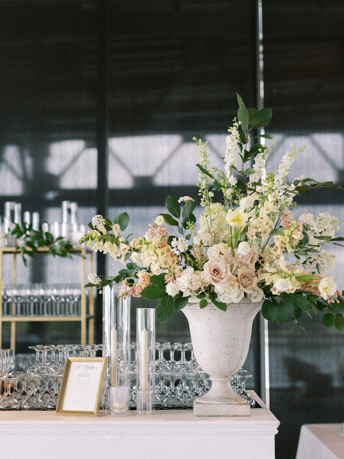 A large arrangement of pastel flowers sits on the bar at a Science Centre wedding reception.