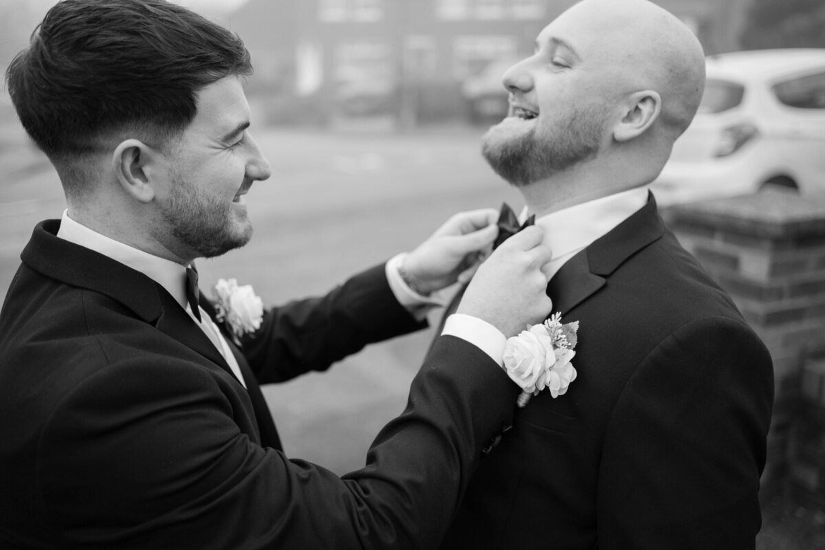 Groom and best made fixing groom's bowtie