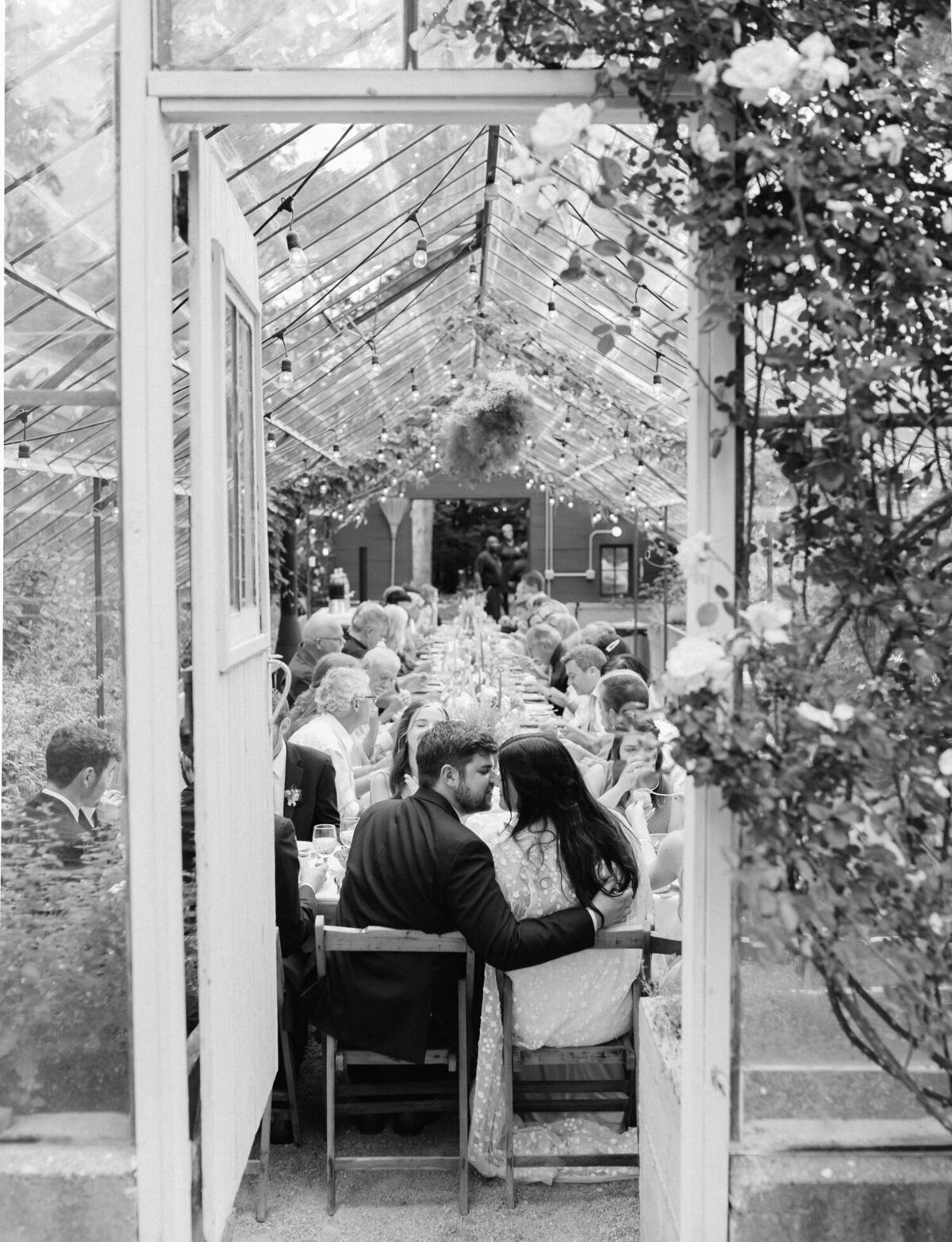 couple kisses at wedding greenhouse dinner at Glass House Community, Grand Rapids