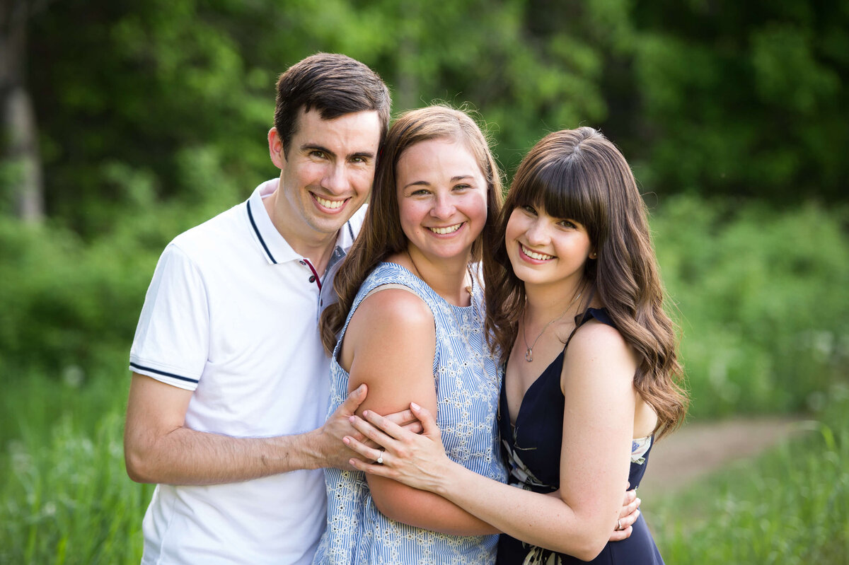 three adult siblings hugging and smiling during their outdoor family session  captured by Ottawa Family Photographer JEMMAN Photography