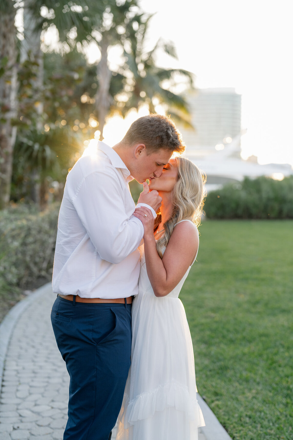 Couple kissing with sun behind them