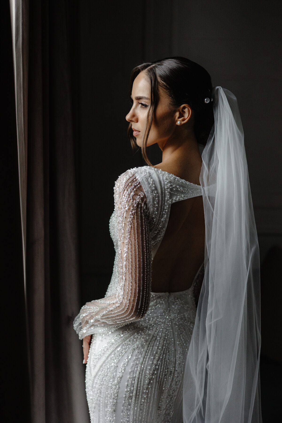 woman-wedding-dress-looking-out-window