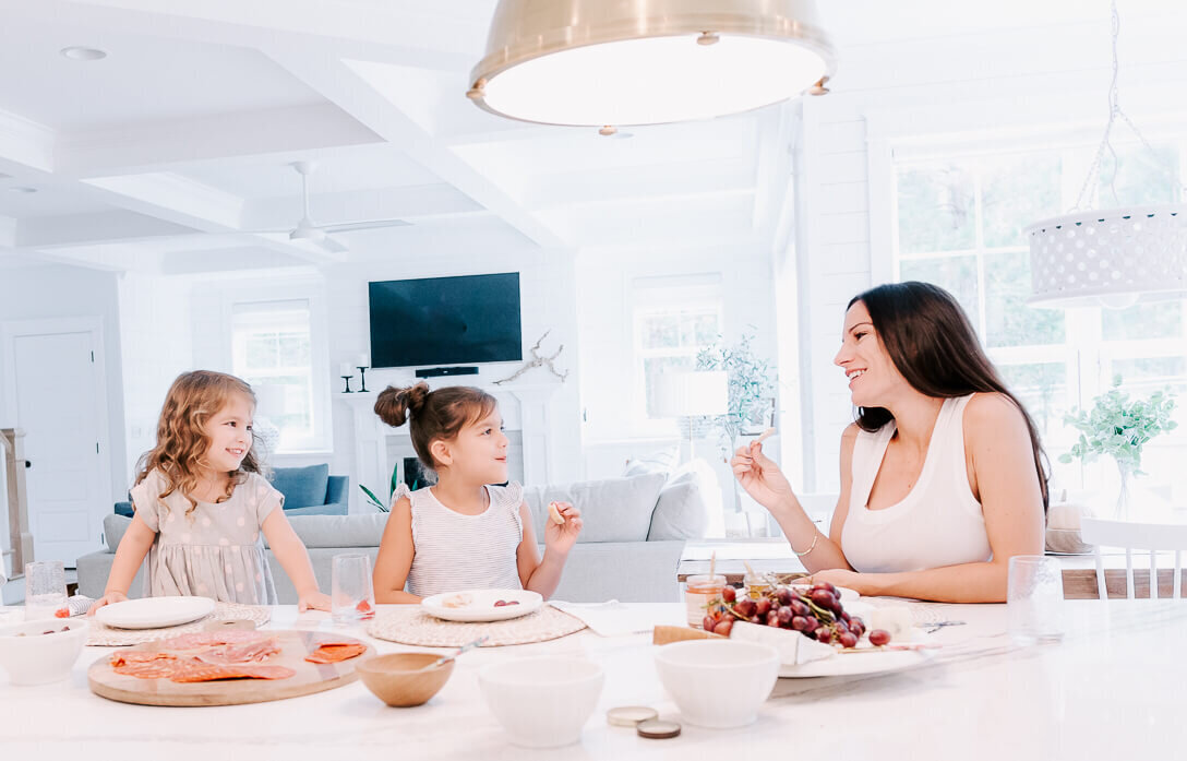 mom with two daughters eating snacks  in house in raleigh