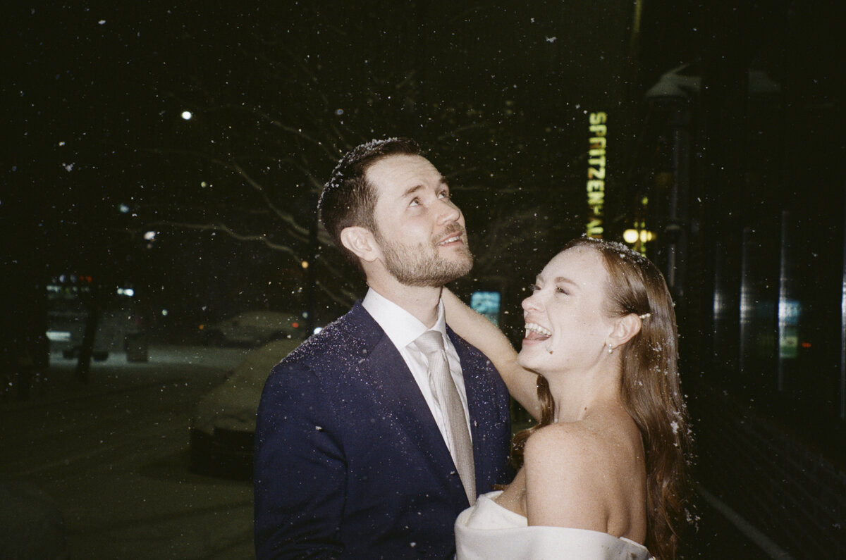 Candid wedding photo of bride and groom in the snow outside in the Hudson Valley shot on 35mm film