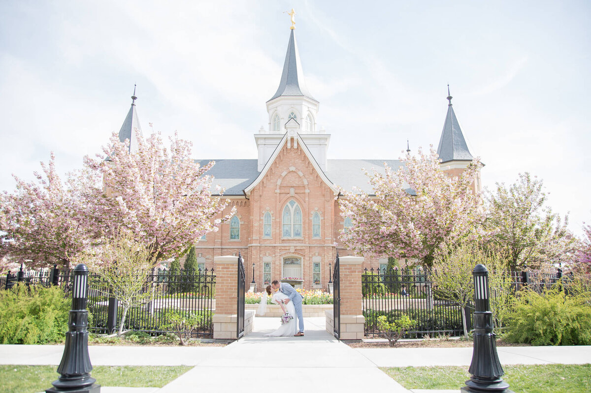 a bride and groom kissing in front of the provo city center lds temple by las vegas wedding photography expert , jessica Bowles