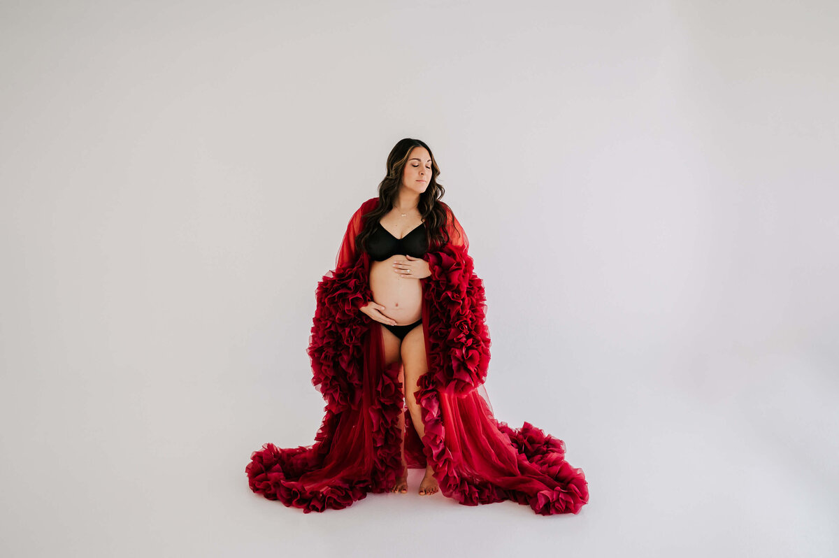 Joplin Mo maternity photographer Jessica Kennedy of The XO Photography captures maternity photo of mom holding baby bump closing eyes in studio