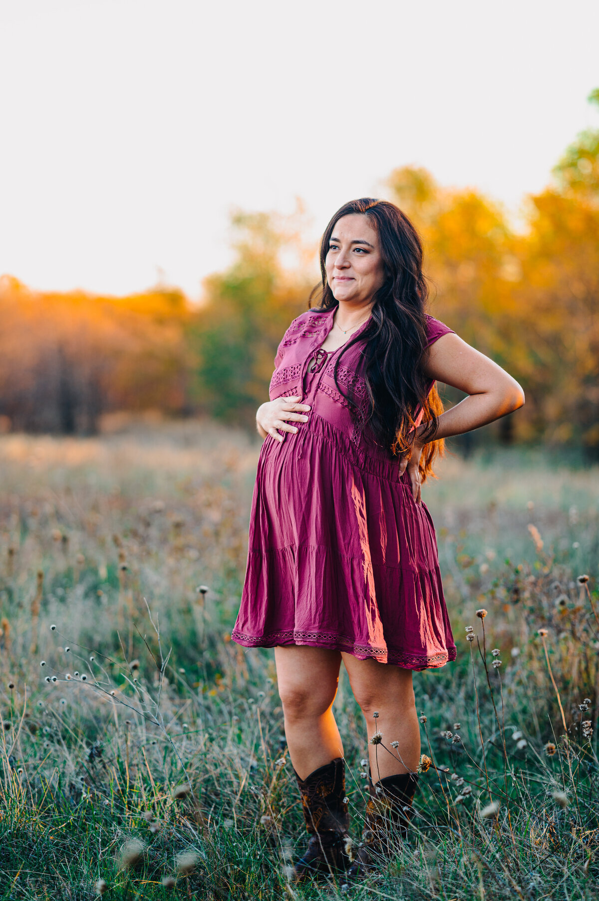 mom posing holding belly at sunset 