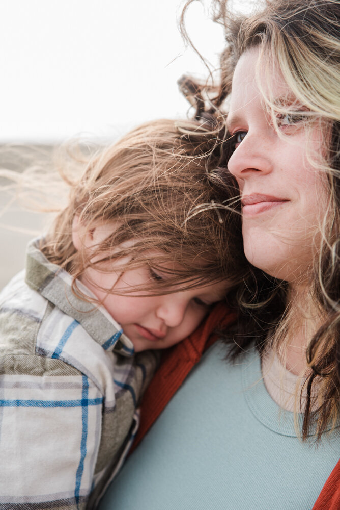 Boy snuggling his mom, lifestyle family beach photos