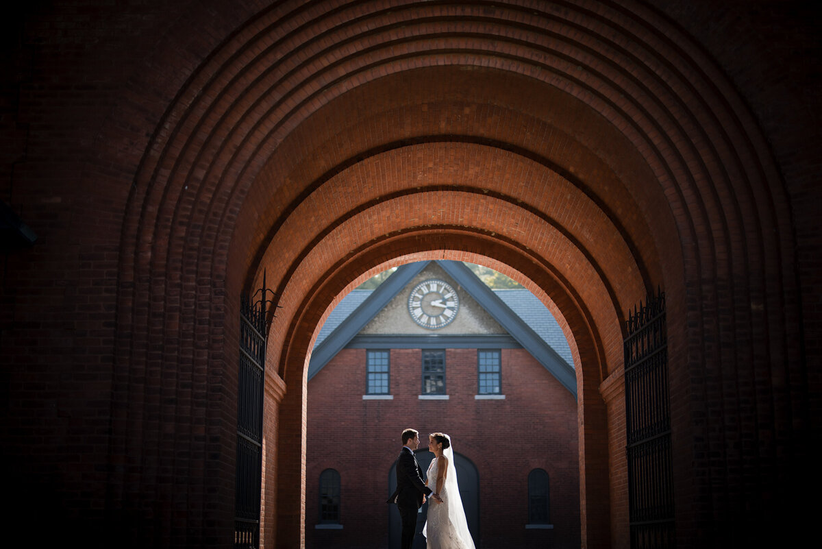 A bride and groom take photos at Shelburne Farms at a destination wedding in Vermont