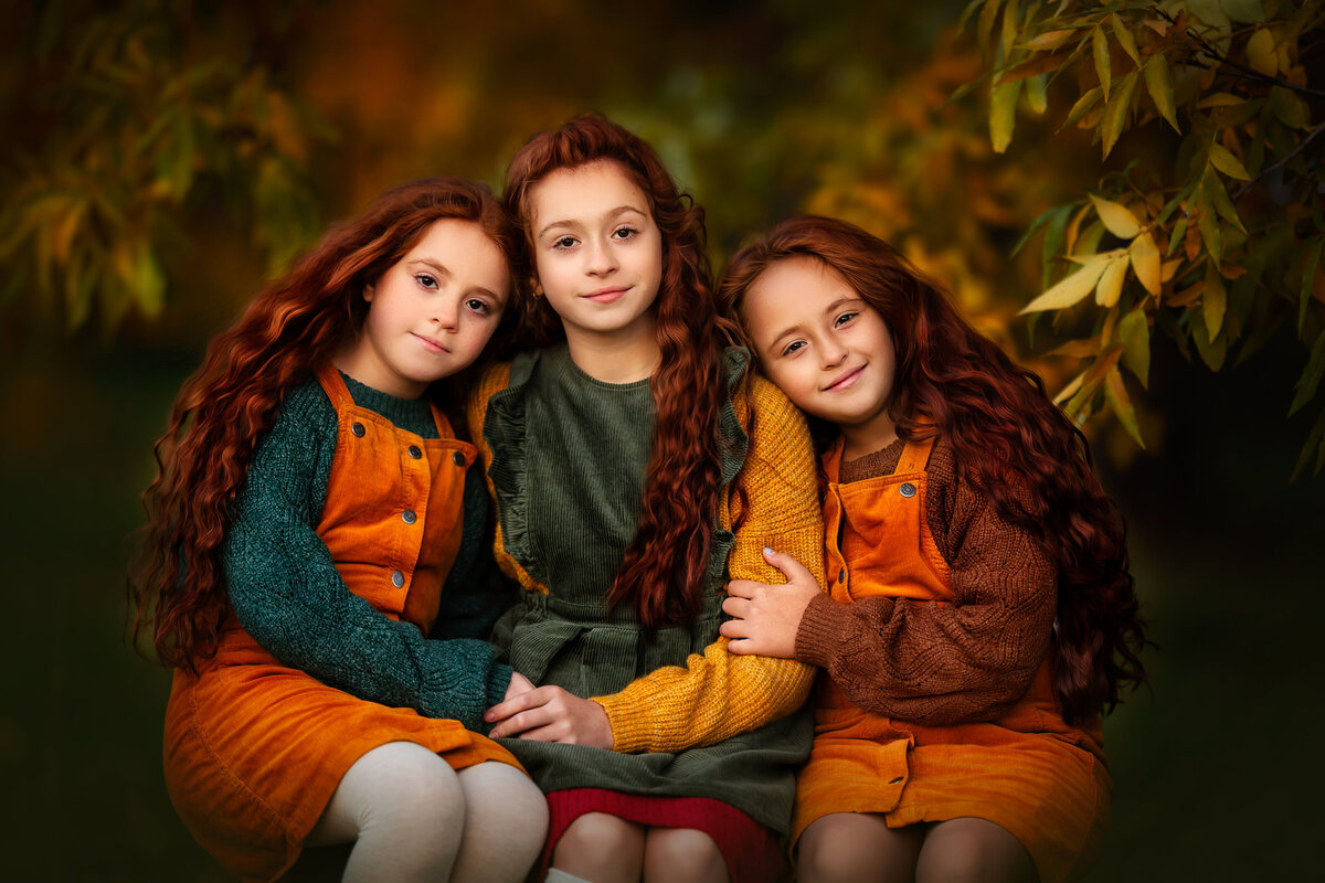 beautiful long ginger hair  siblings are hugging in colorful fall outfits.