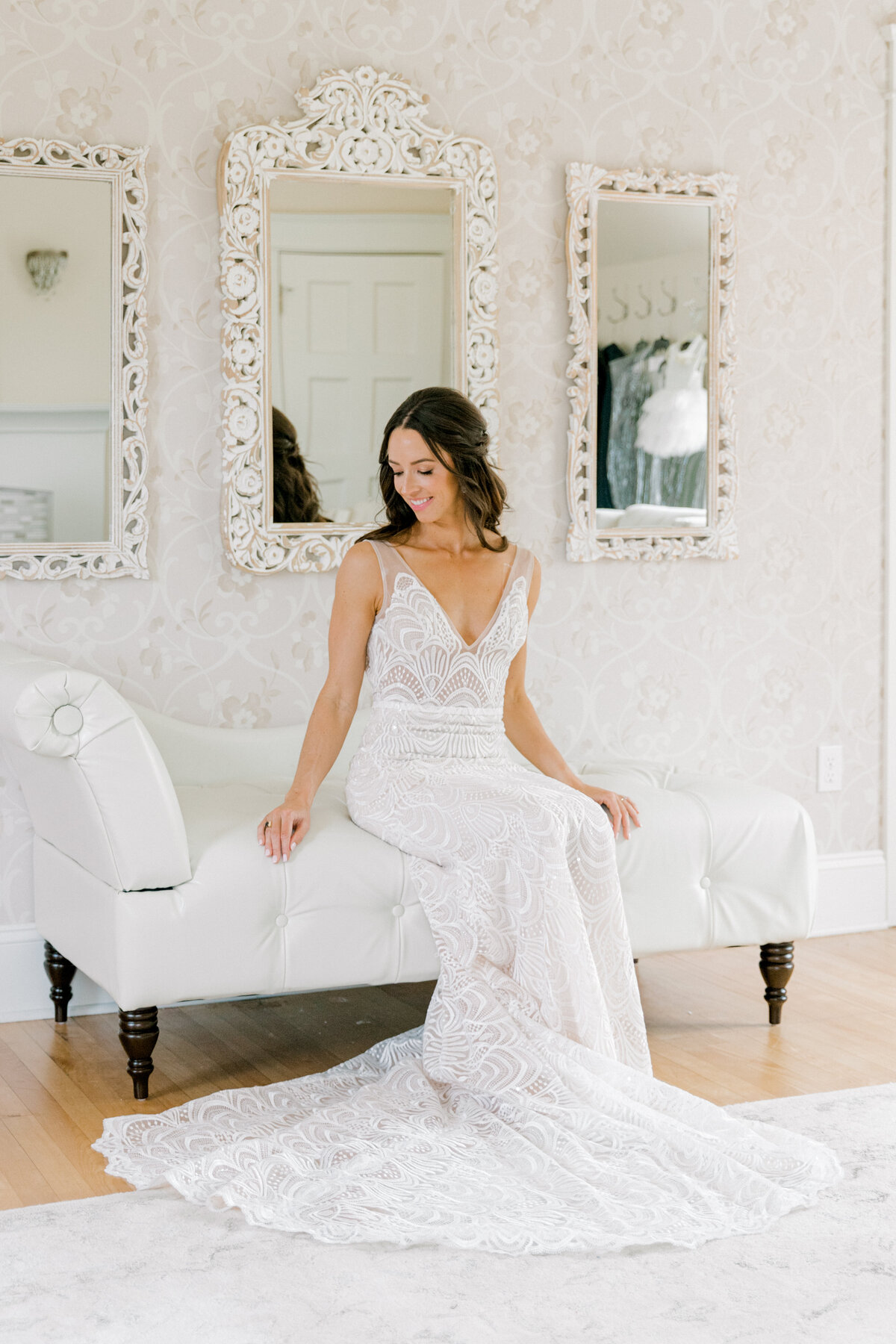 bride sitting on a white couch in the bridal suite  looking down