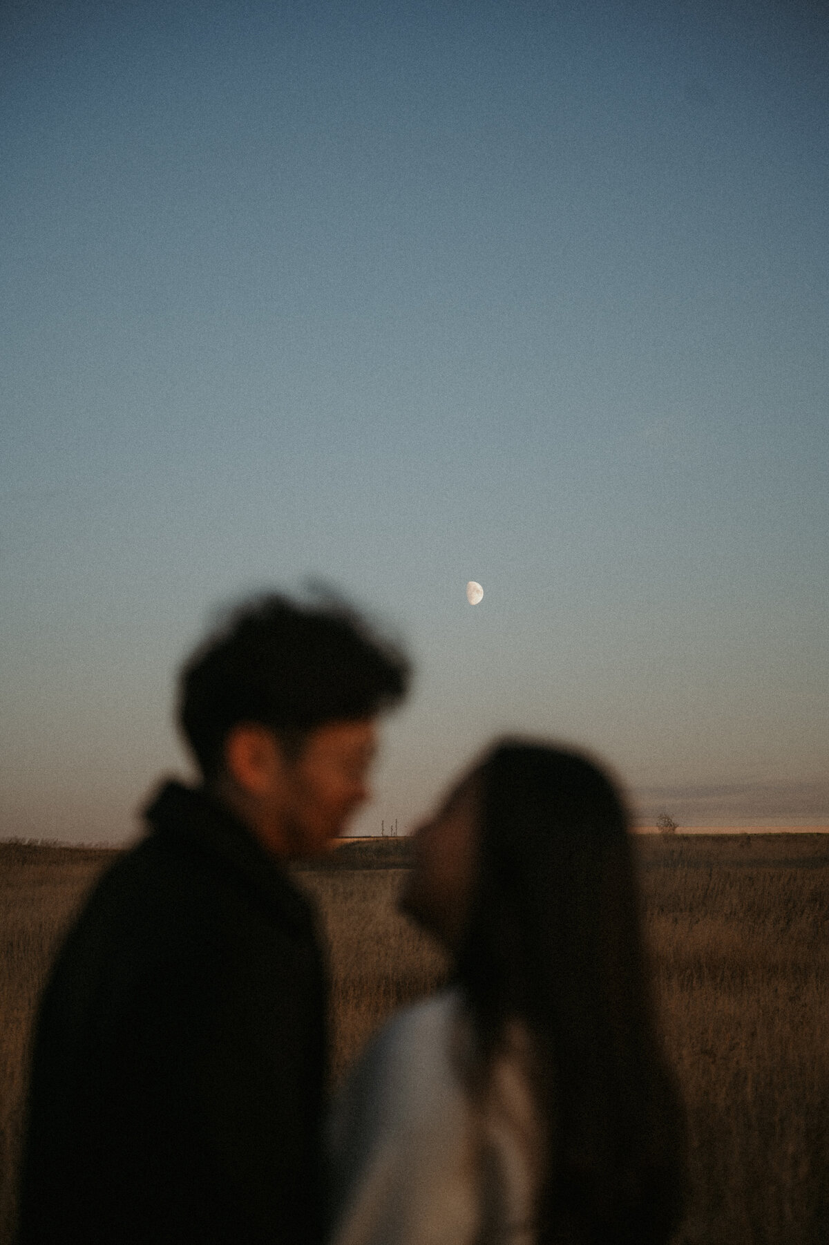 Photograph of couple gazing into each others eyes under moonlight in Alberta