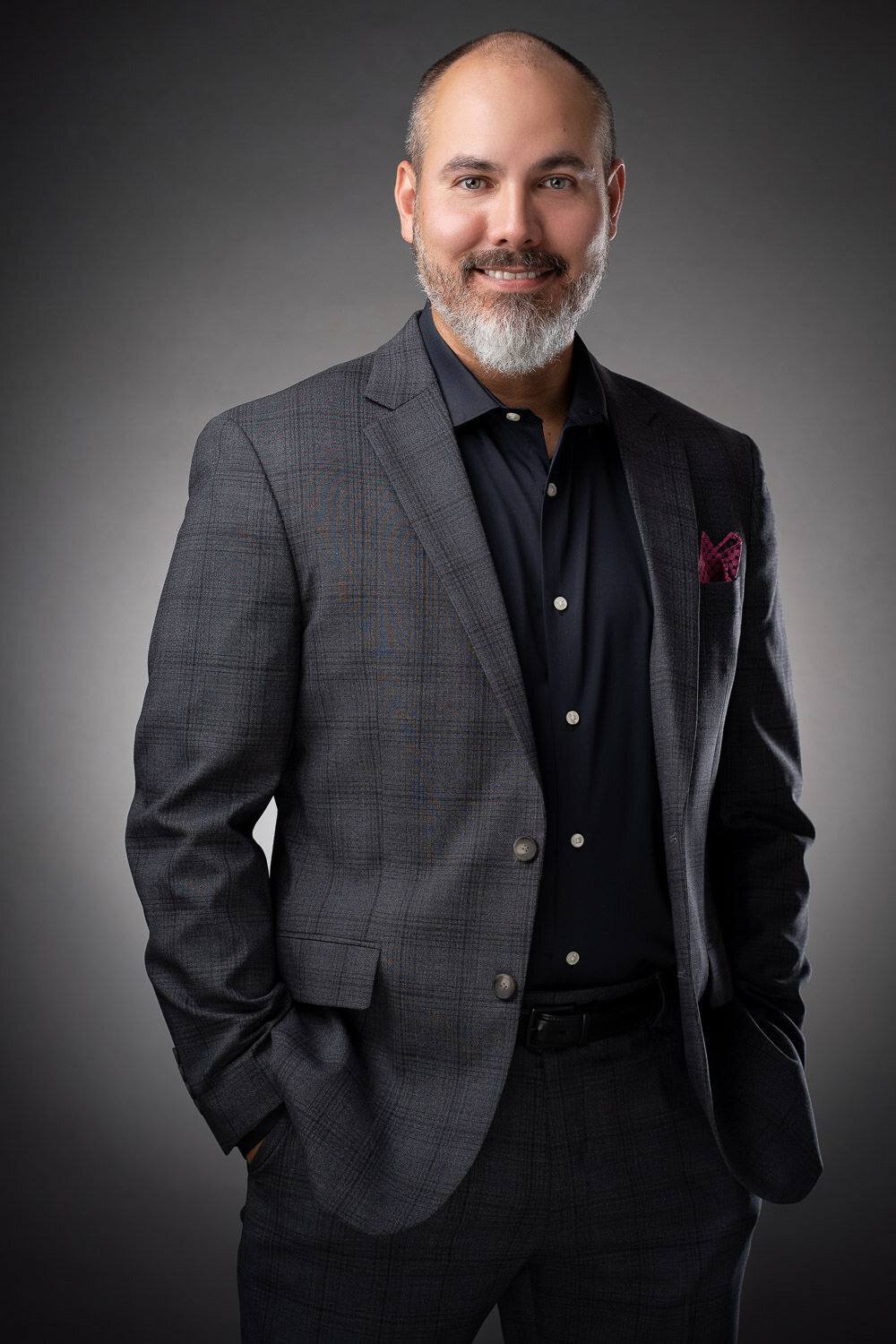Editorial-style headshot on grey background with modern, professional styling.