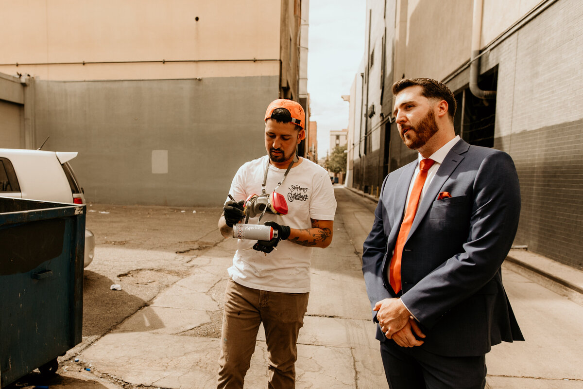 artist signing a spray can for grooms in downtown Albuquerque