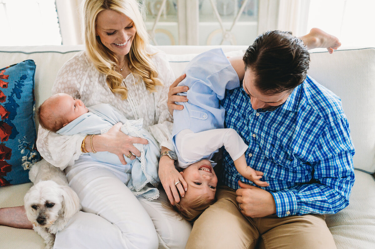 family of four at home with new baby and dog