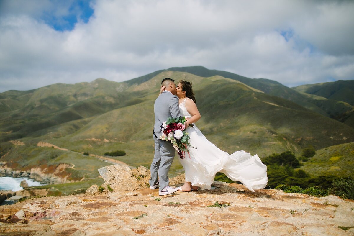 A bride and groom stand on a hilltop in Big Sur on their elopement day