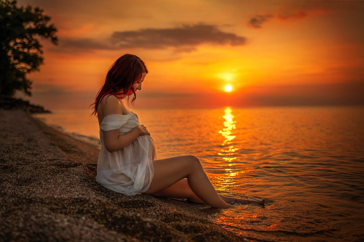 Golden hour sunset maternity photoshoot with expecting mother at the beach