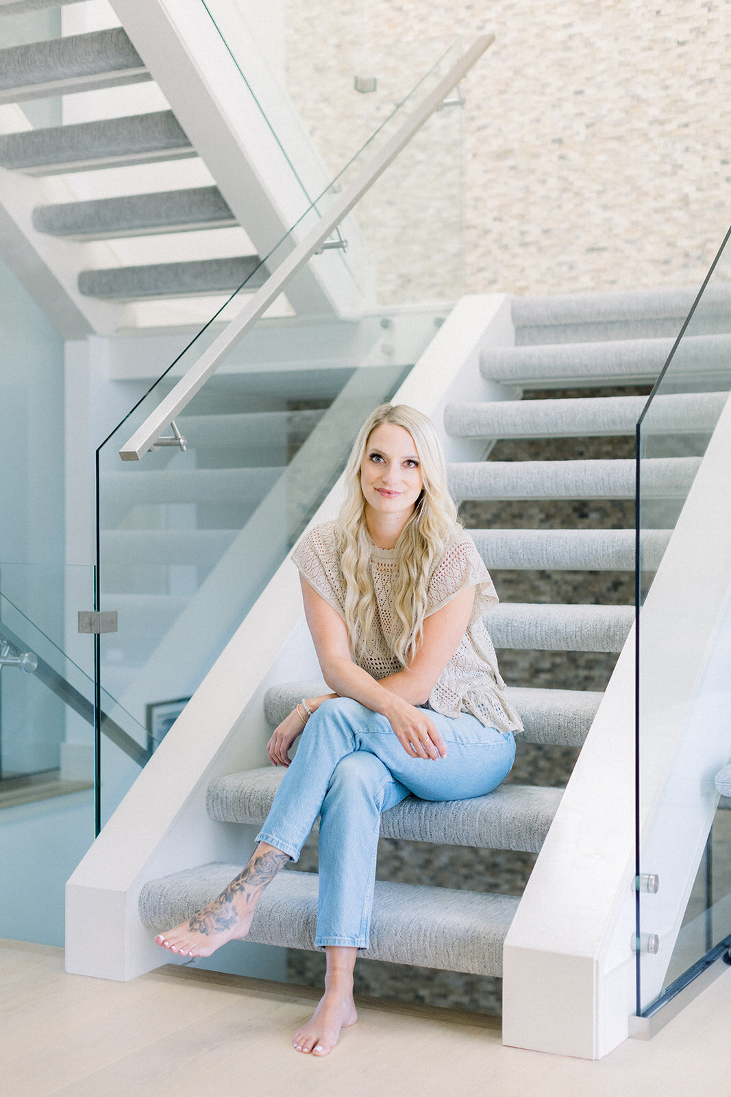 Brand photo of Calgary business woman sitting casually on a set of stairs