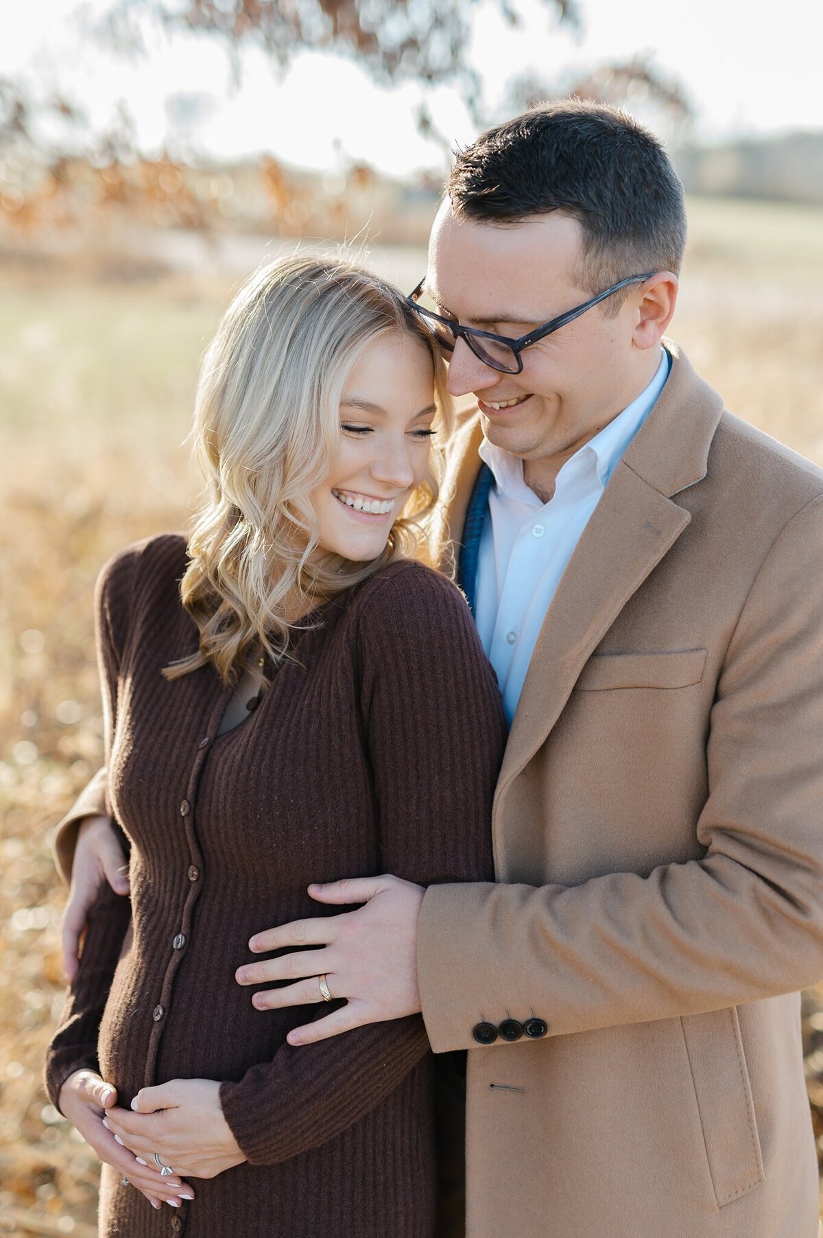 Parents to be smiling at eachother during Milwaukee maternity session