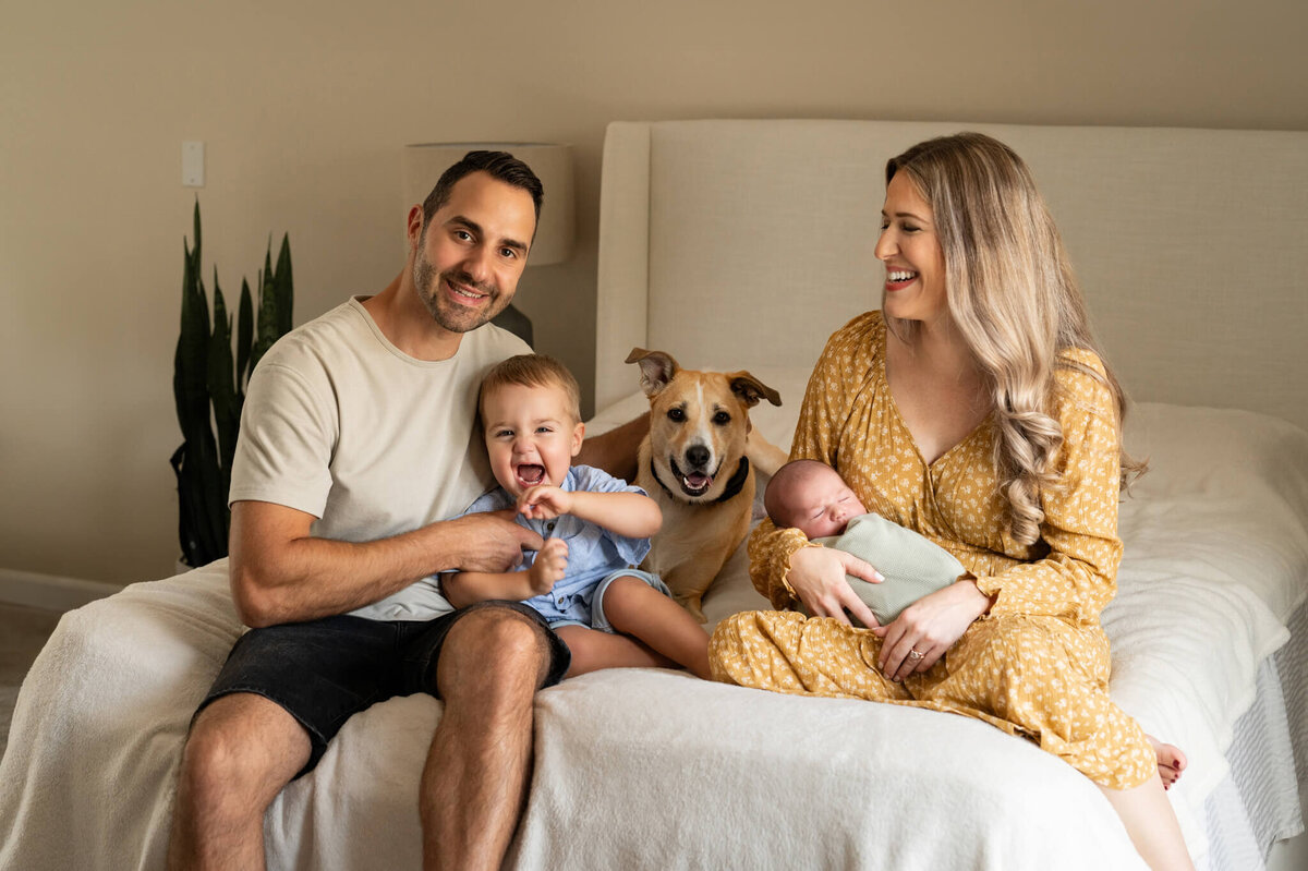 Family photos on a bed with newborn
