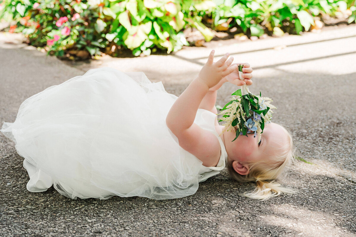funny flower girl photo while she lays on the ground