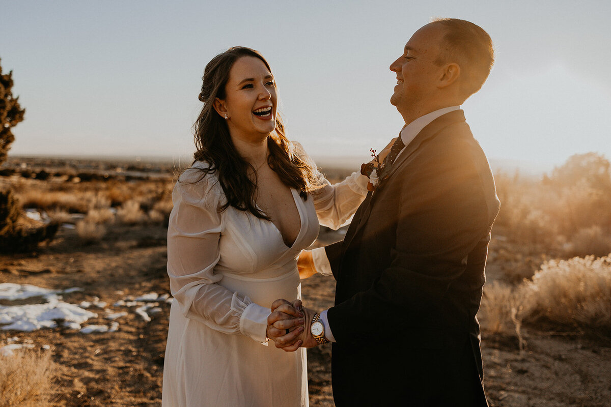 bride and groom laughing together in the desert