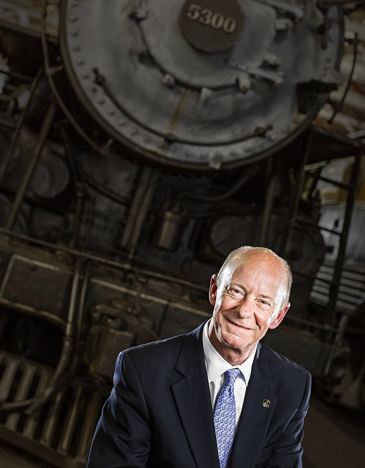 A man smiling in front of a train