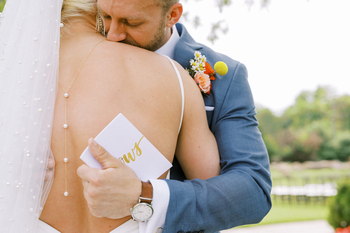 groom-hugging-bride-tightly-with-vow-book