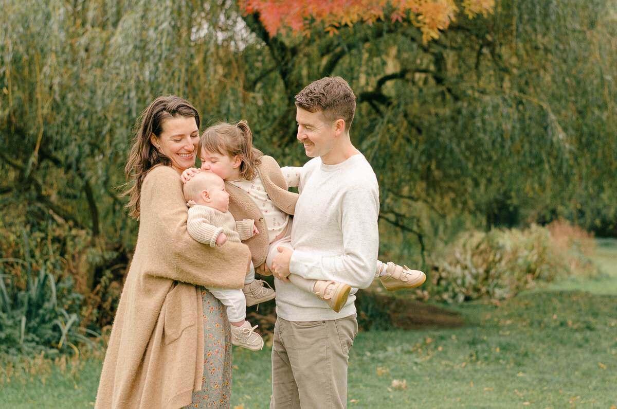 Family cuddles in during a photoshoot at Vondelpark in Amsterdam.