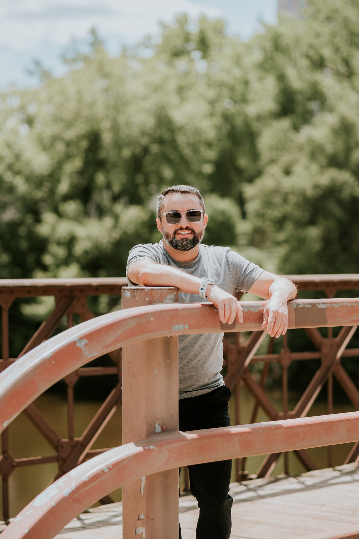 Natural lifestyle dating profile photo of a man leaning casually on a Minneapolis bridge, captured to highlight a friendly, easygoing personality for dating apps.