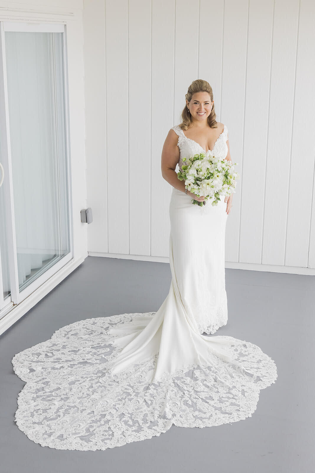 Bridal portrait wearing lace wedding dress with white florals
