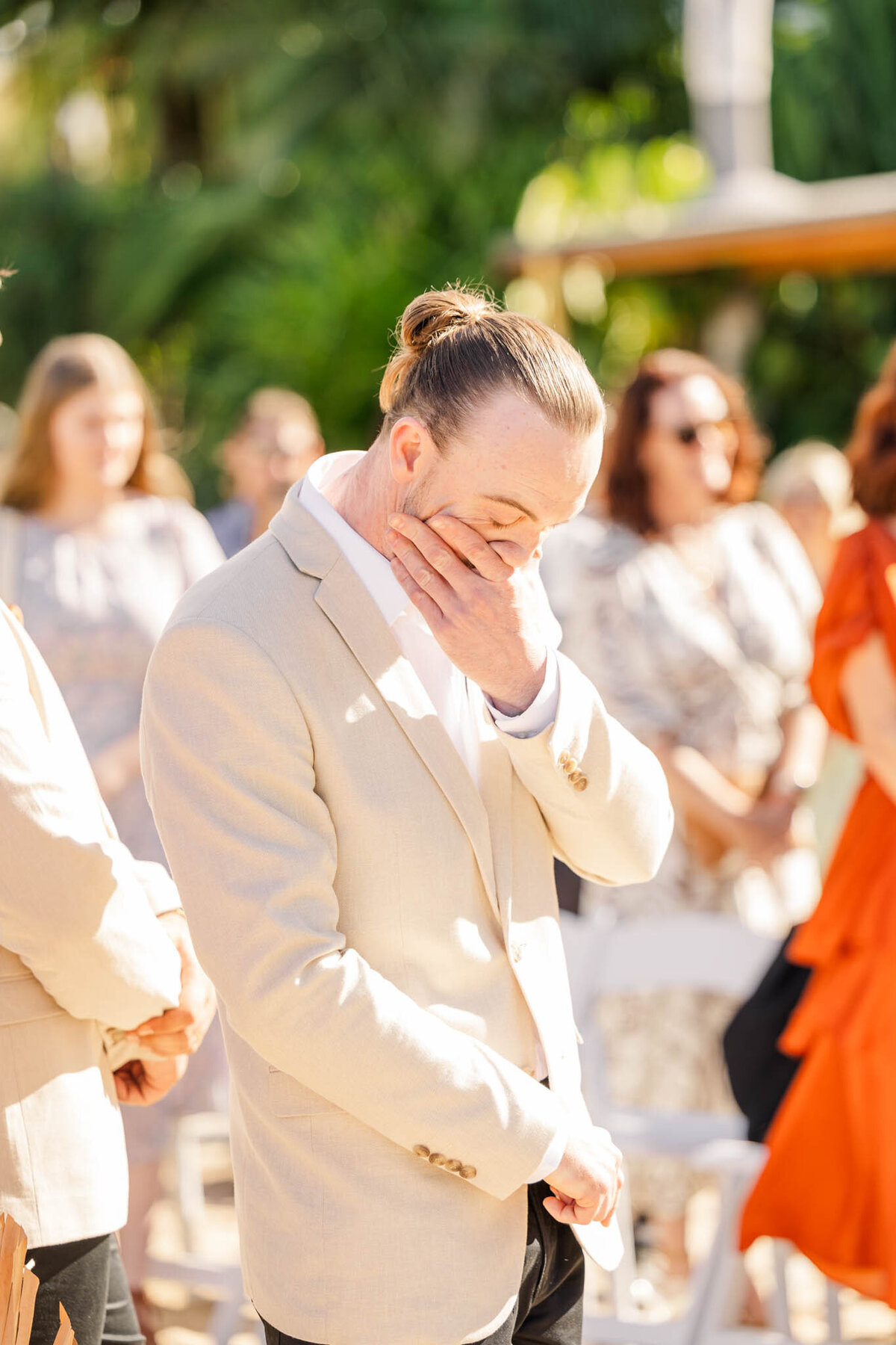 Emotional groom stands at the end of the ceremony, waiting for his bride to walk down the isle to him