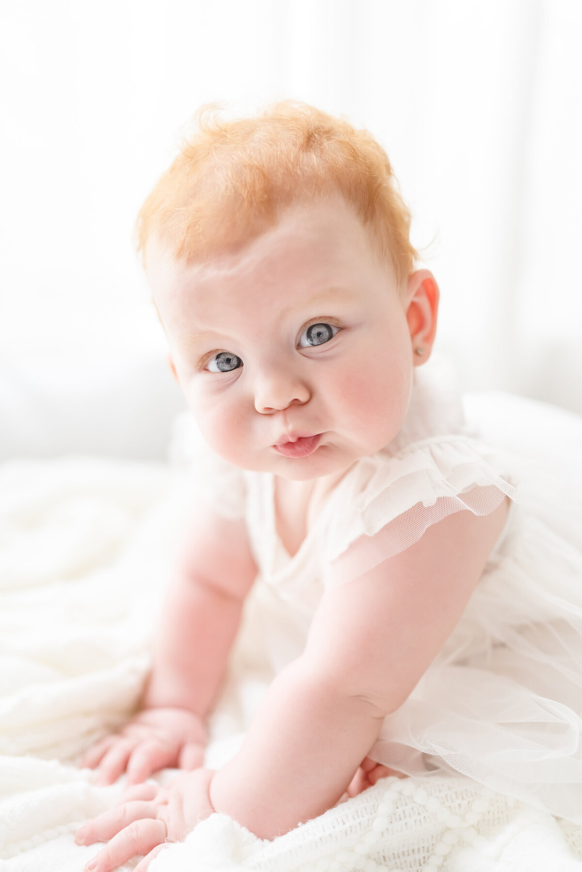 Baby and child photographer in Chandler, AZ baby girl with red hair and blue eyes looking at camera