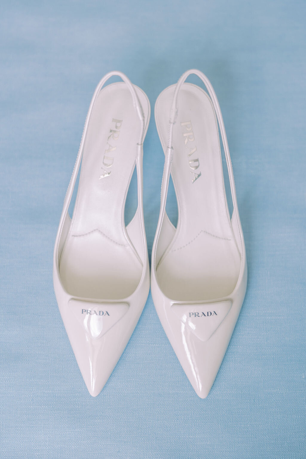 brides prada white shoes on baby blue backdrop