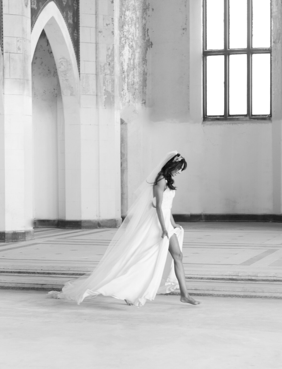 barefoot bride in long veil runs through abandoned cathedral wedding venue in Italy