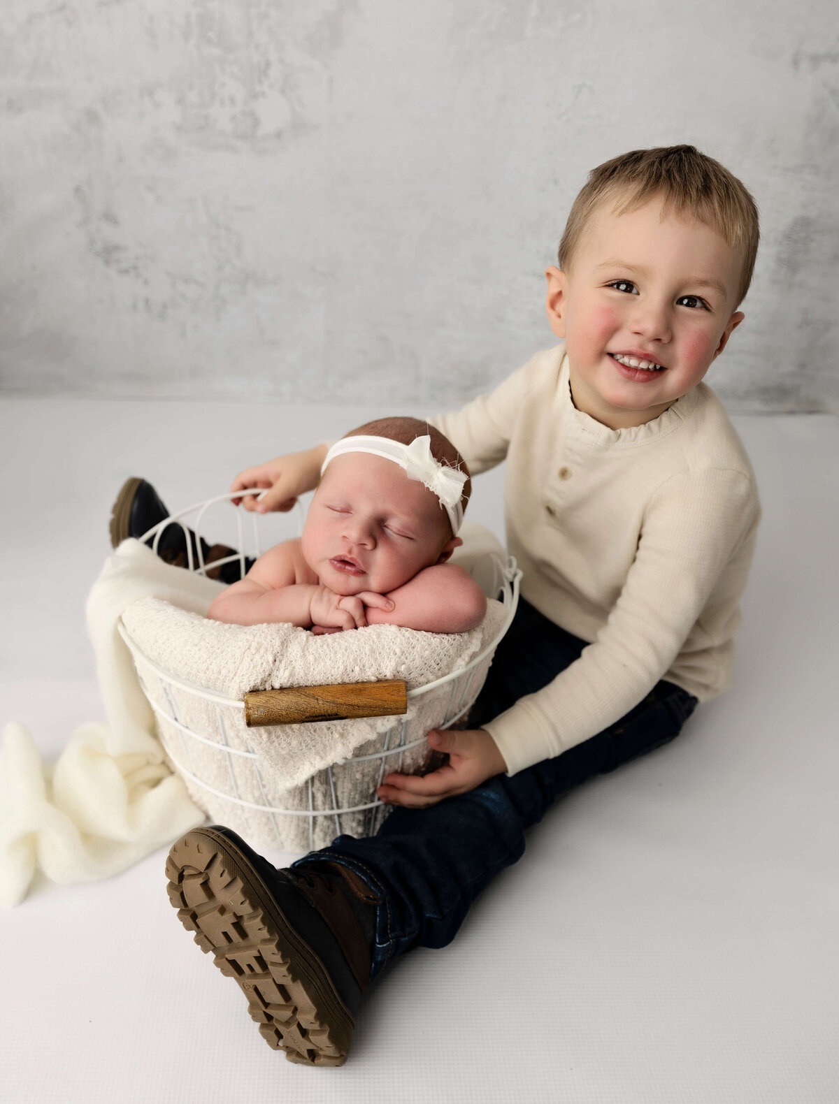 Big brother and newborn baby sister posed in an Erie Pa photography studio