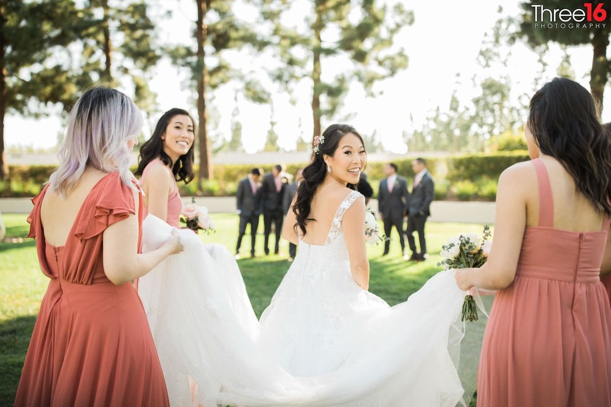 Bridesmaids carries Bride's train during the photo shoot