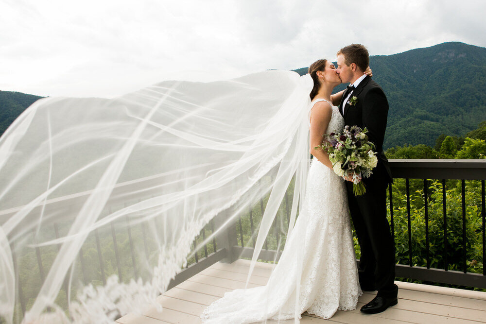 bride's veil flies in the wind during her linville gorge elopement