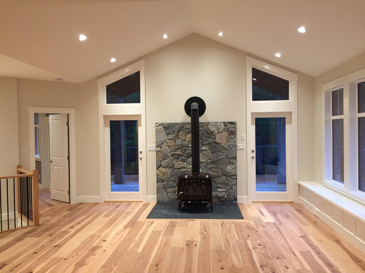 Craftsman style home interior with wood burning fireplace and vaulted ceilings.