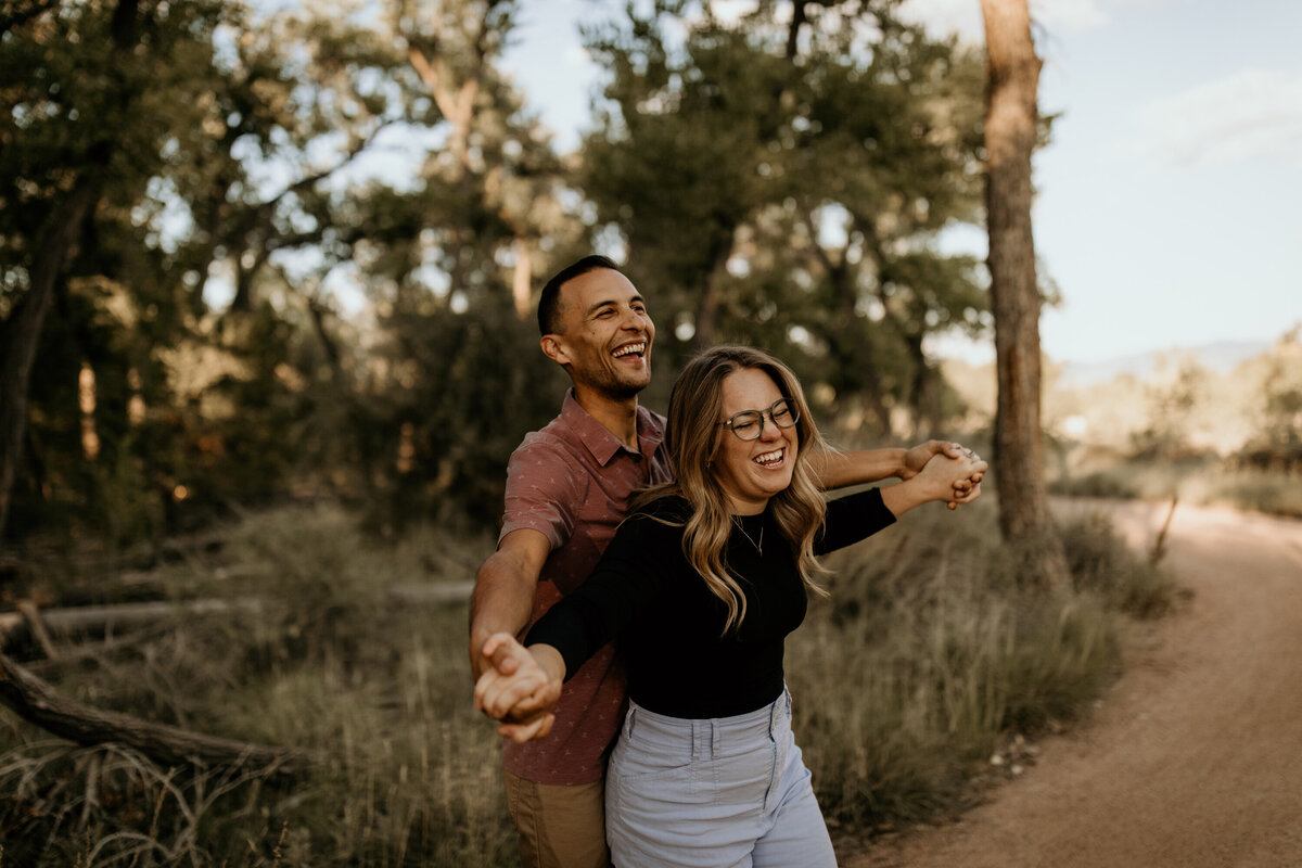 engaged couple laughing together on a trail in Albuquerque